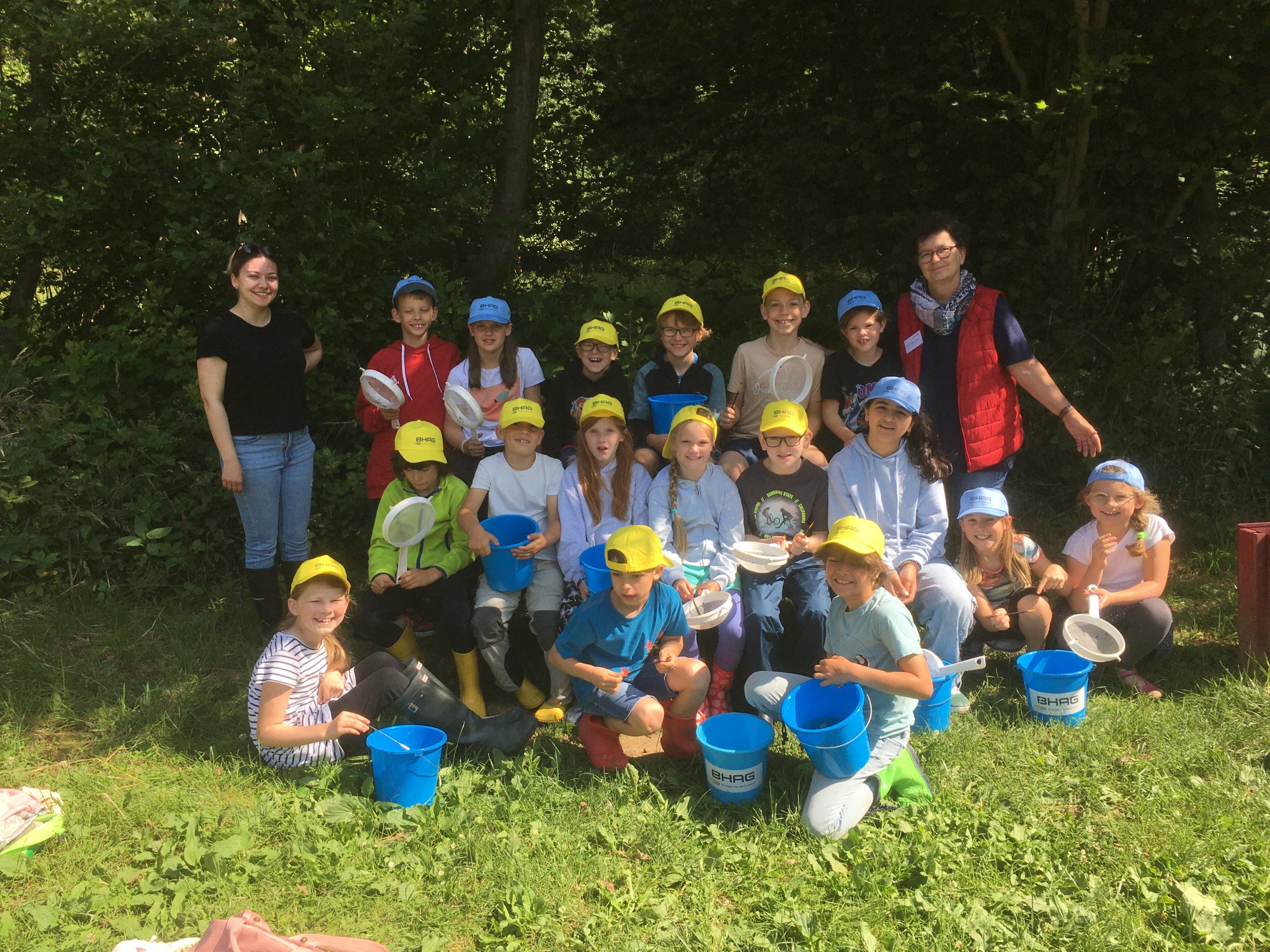Kinder mit Eimern beim Wasser-Workshop in der Grundschule Windhagen.