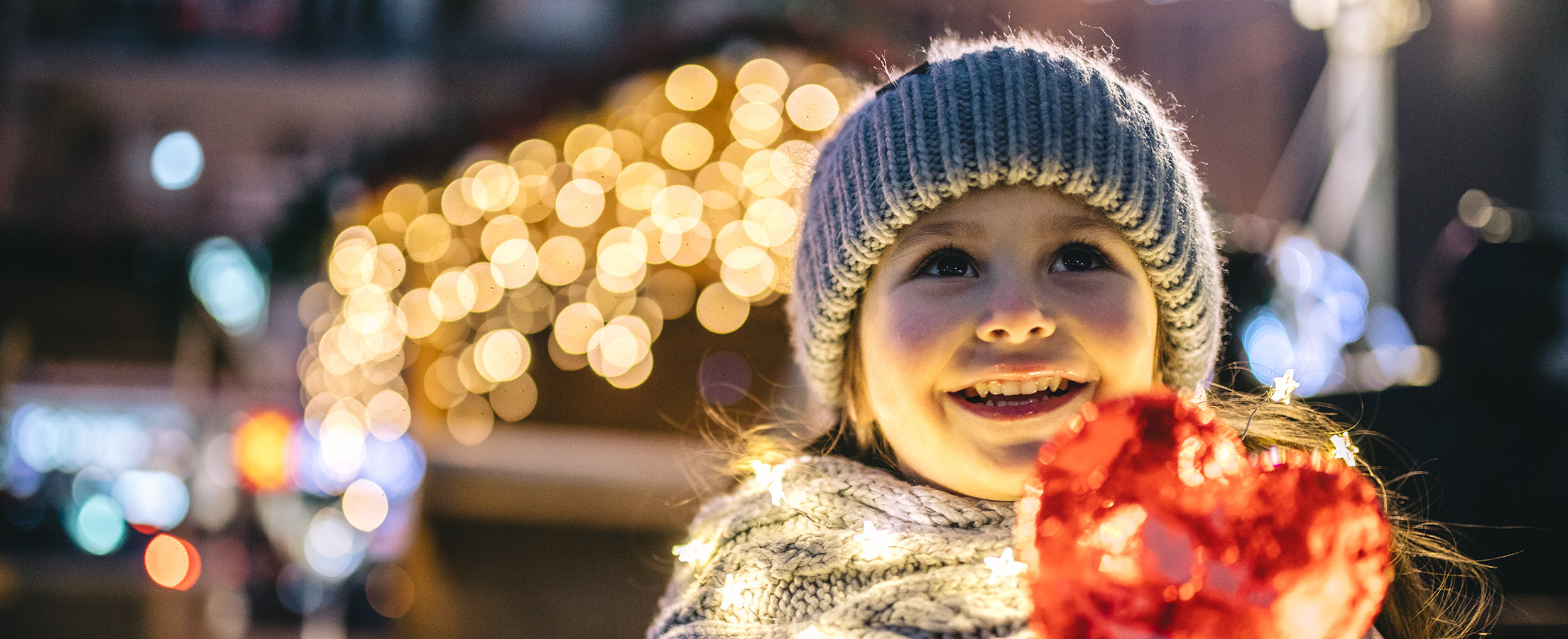 Mädchen freut sich an der Weihnachtsbeleuchtung in der Innenstadt.