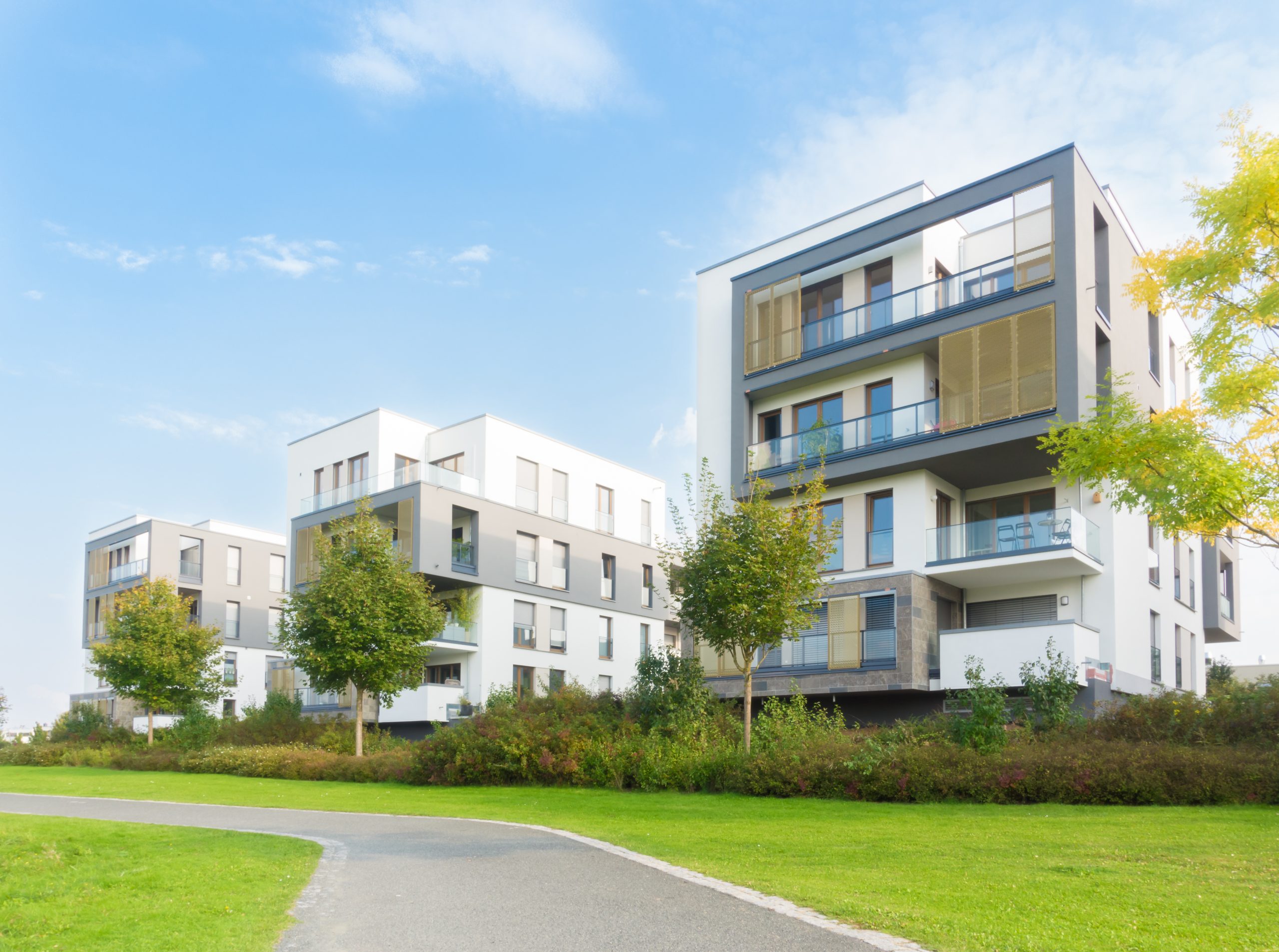 Neubausiedlung und Fußweg in einer Parkanlage.