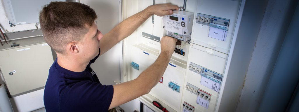 Elektromonteur baut eine moderne Messeinrichtung ein.