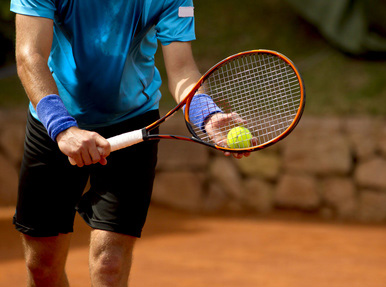 Tennisspieler mit Ball und Schläger