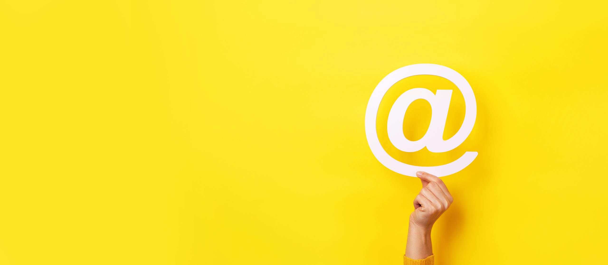 email sign in hand over yellow background, panoramic layout